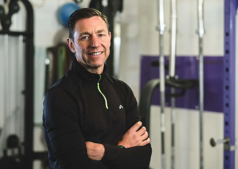 Coach Paul Armstrong, arms folded, smiling